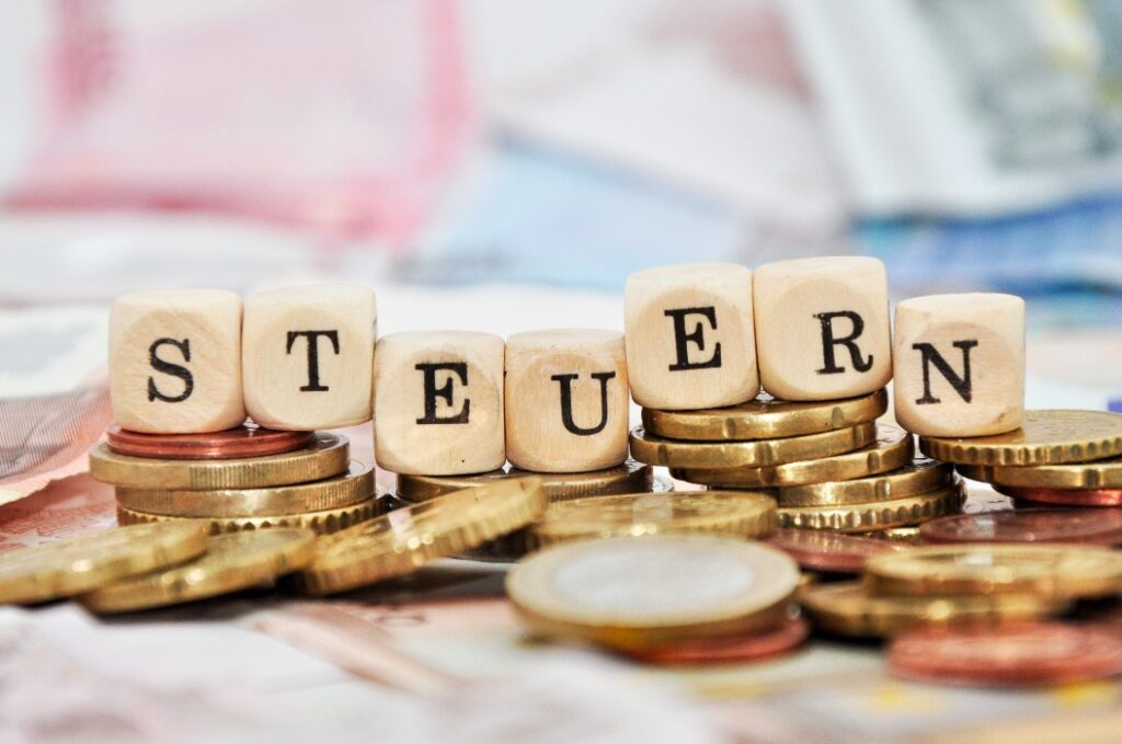 Würfel auf Geld mit dem Aufdruck Steuern